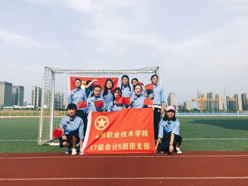 活动中大家身着班服在操场的各个角落与团旗合影,留下一张张灿烂的